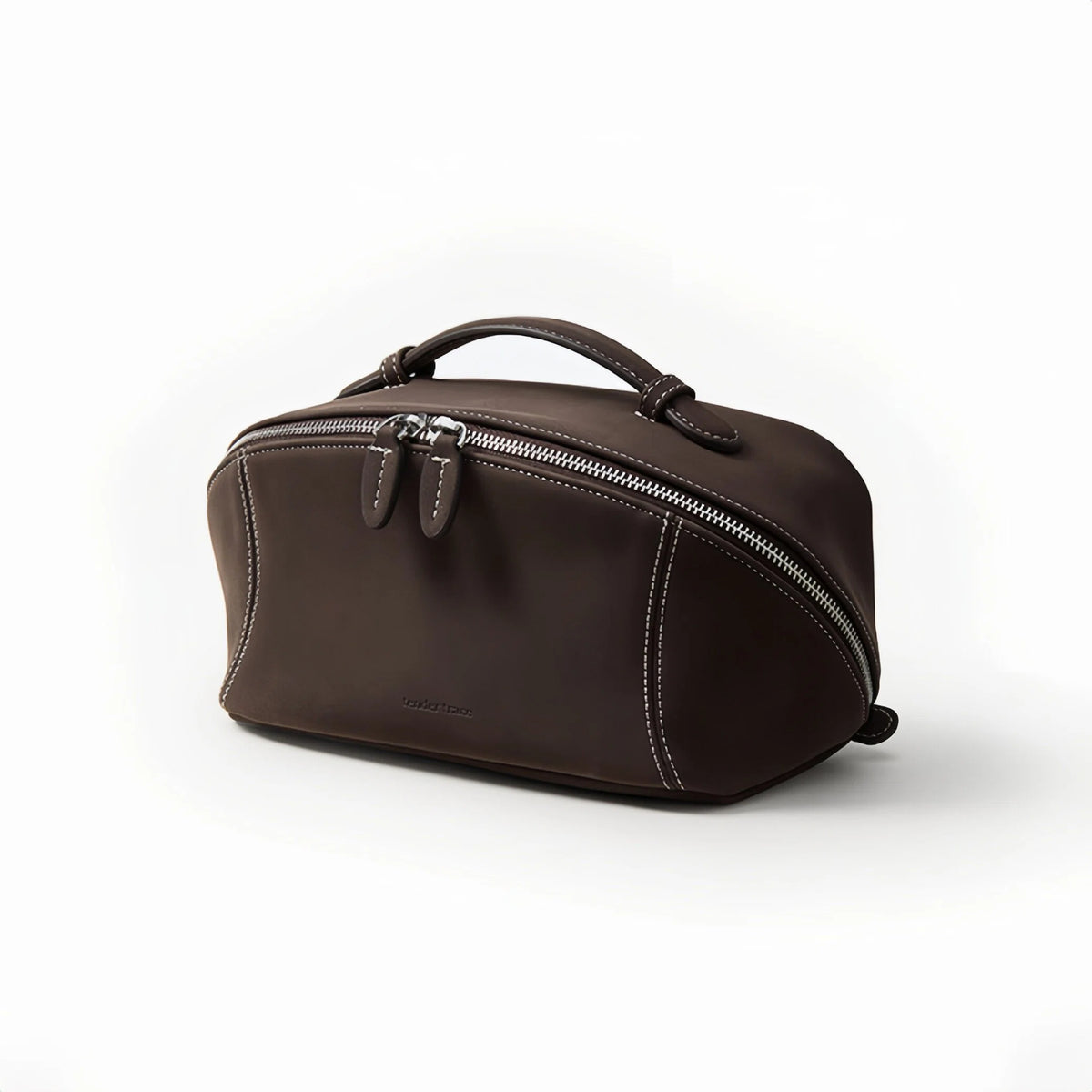 A dark brown makeup bag with a top handle, curved zipper, and white contrast stitching, shown on a clean white background.