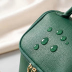 Green makeup bag with water drops on a light background