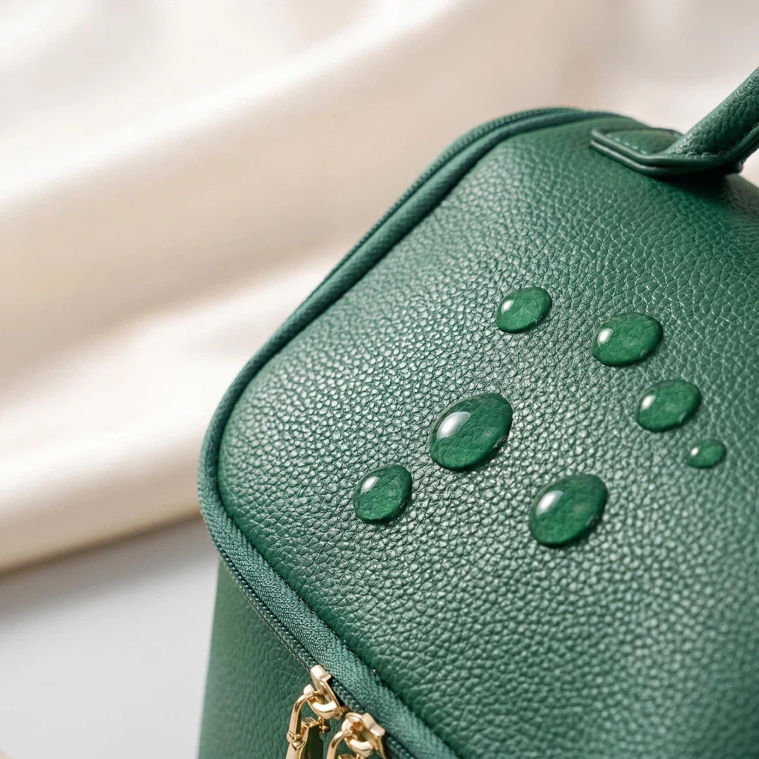 Green makeup bag with water drops on a light background