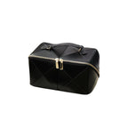 Black geometric makeup bag with gold zipper on a white background