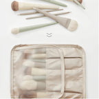 Makeup brushes with a clear pouch on a light background