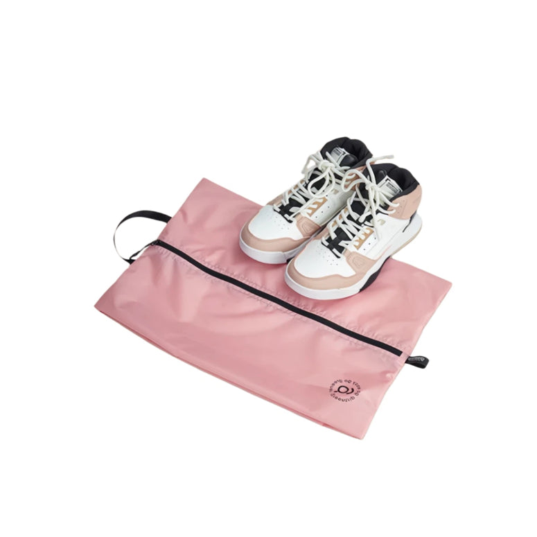 Pink shoe bag with white and beige sneakers on a white background