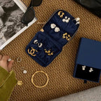 Jewelry set with gold and silver earrings displayed on a textured surface.