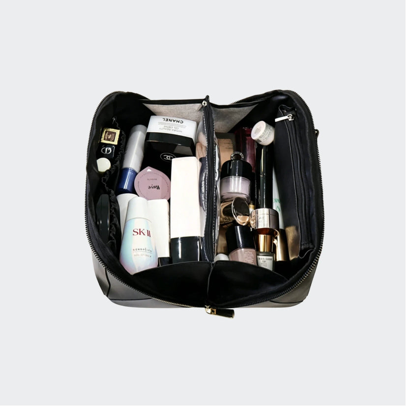 Open makeup bag with various cosmetic products on a light gray background