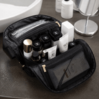 Black makeup bag with cosmetic products on a bathroom counter