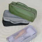 Set of four hairdryer cases in green, gray, black and purple with a hairbrush inside the purple bag.