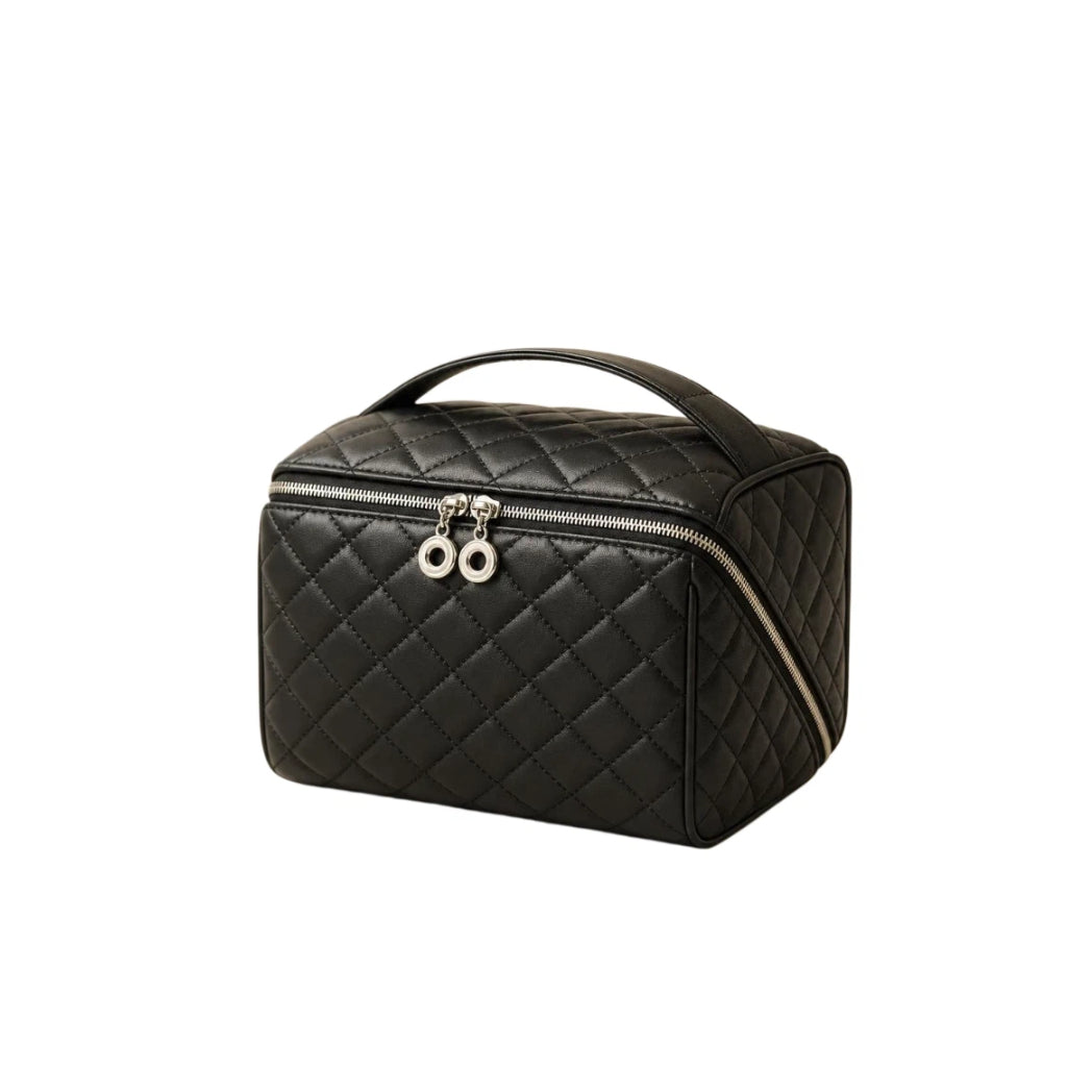 A black quilted cosmetic bag with a top handle, zippered closure, and silver-tone hardware, shown on a plain white background.