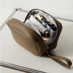 Olive grey makeup bag filled with cosmetics products