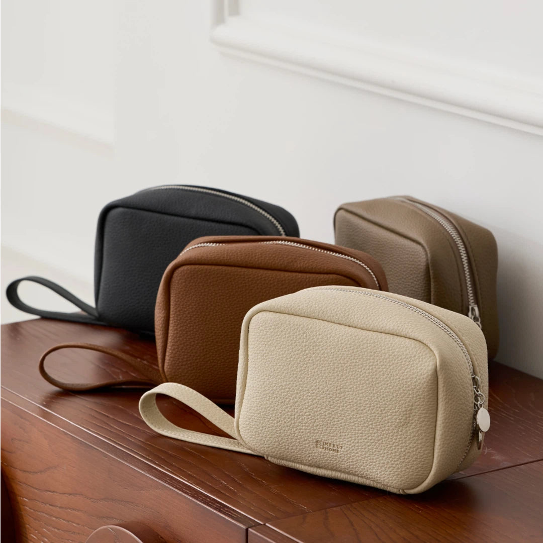Makeup bags in four colours on a wooden surface