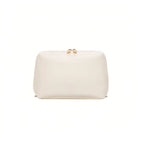A cream cosmetic bag with a small gold bow detail on top, shown against a plain white background.
