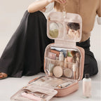 Person holding a pink travel makeup organizer with various items inside.