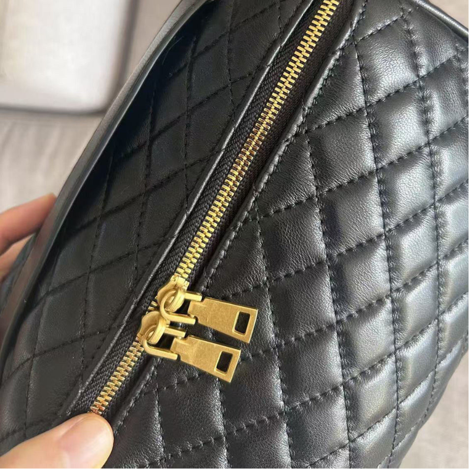 Close-up of a black quilted makeup bag with a gold zipper