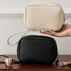 Black and beige makeup bags on a wooden surface
