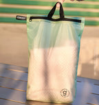 Clear green travel bag with black zipper held by a hand.