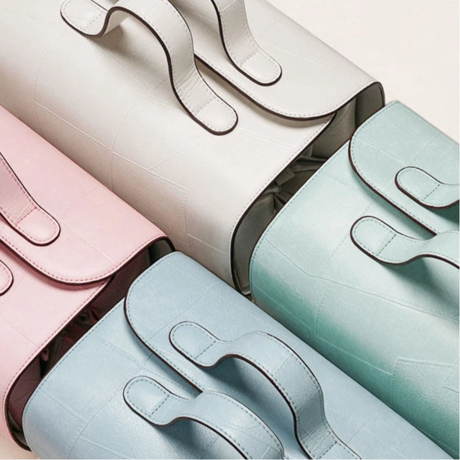 Four colorful makeup bags arranged in a row on a light background