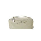 Green makeup bag with a bow on a white background