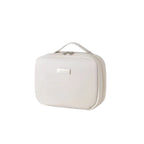 Cream cosmetic bag with a gold tag on a white background