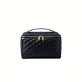 Black quilted cosmetic bag with gold zippers on a white background