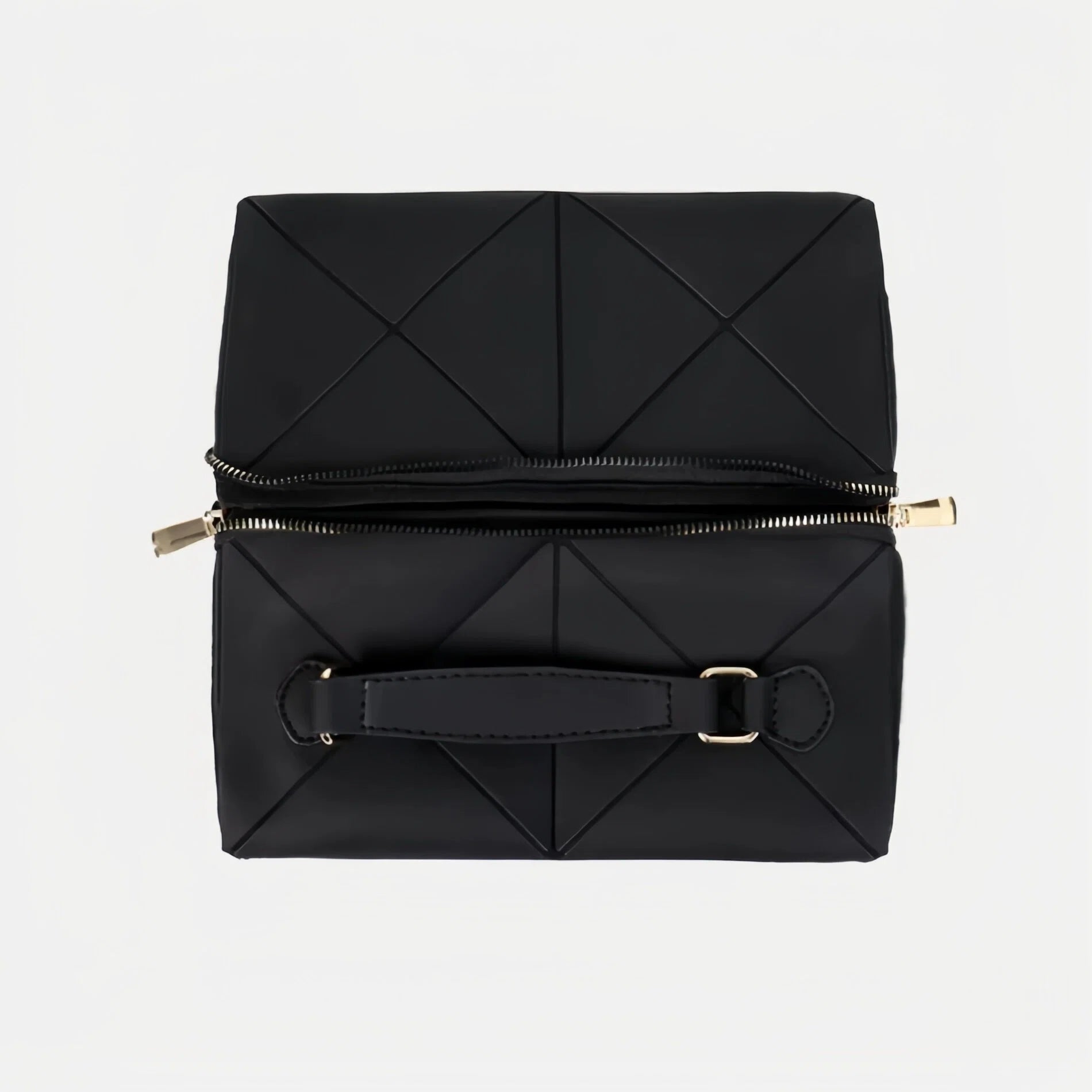 Folded black quilted makeup bag with gold zipper on a light gray background