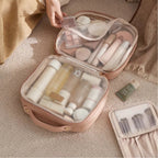 Open pink cosmetic bag with various skincare products on a beige surface