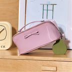 Violet makeup bag with a bow on a wooden surface