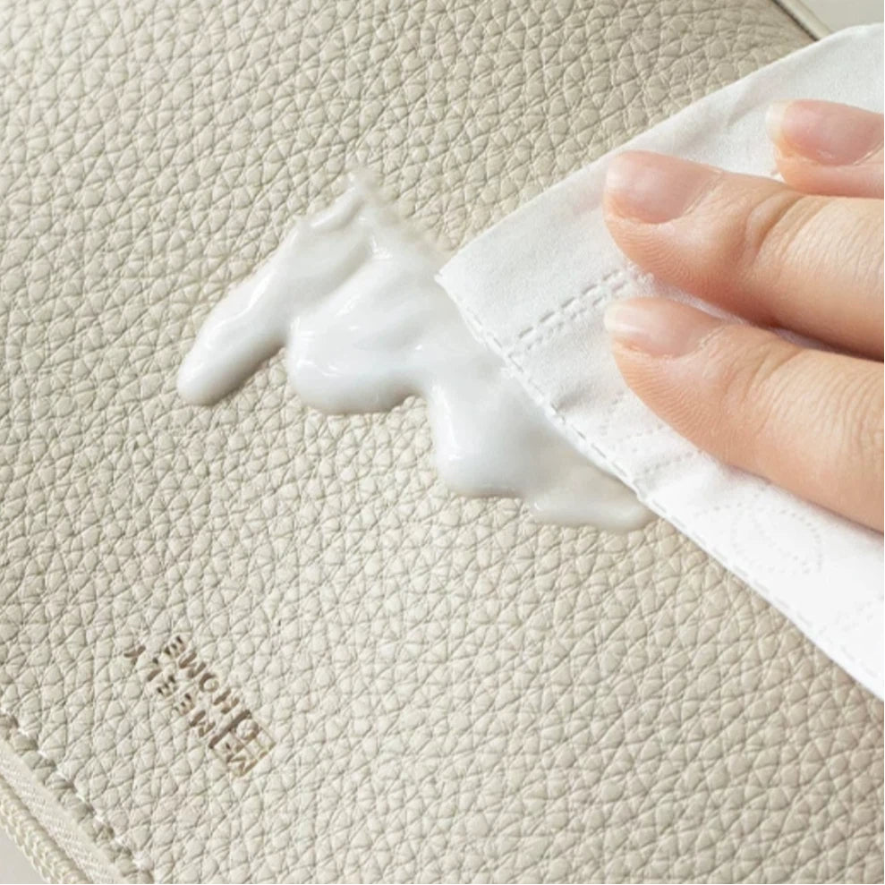 Hand cleaning a textured surface with a white cloth