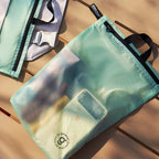 Green travel bag with black handles on a wooden surface