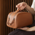Brown leather bag held by a person with a blurred background
