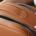 Close-up of a brown leather bag with zipper