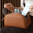 Brown leather bag with a Chanel skincare product being placed inside