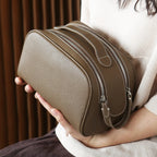 Person holding a brown leather bag with a textured finish