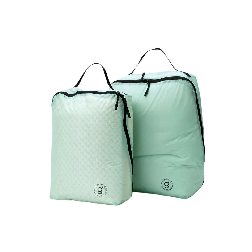 Two light green travel bags with black zippers on a white background