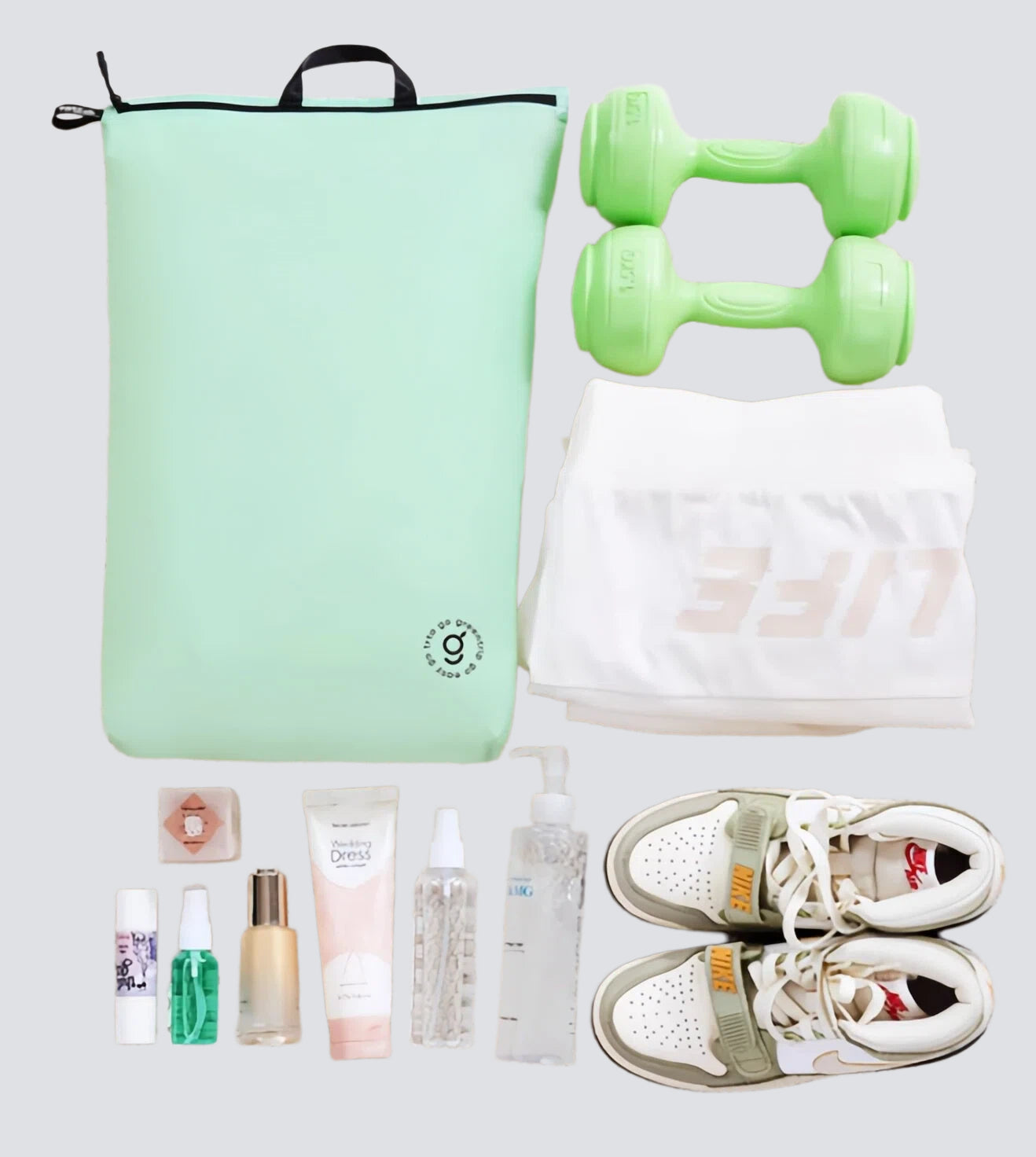 Collection of fitness and lifestyle items including a green bag, dumbbells, sneakers, and personal care products on a light gray background.