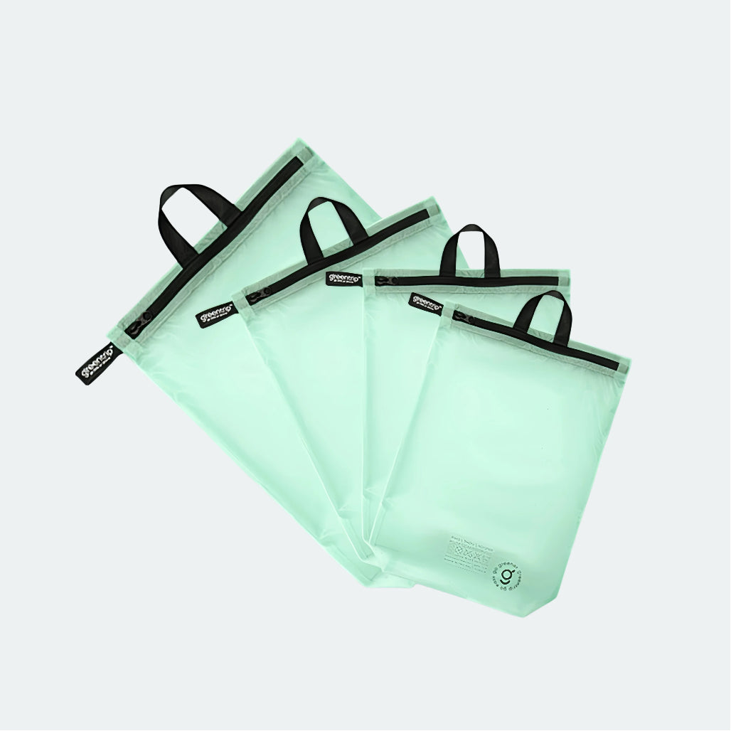 Set of four green travel bags with black handles on a light gray background