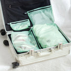 Open suitcase with green travel storage bags inside
