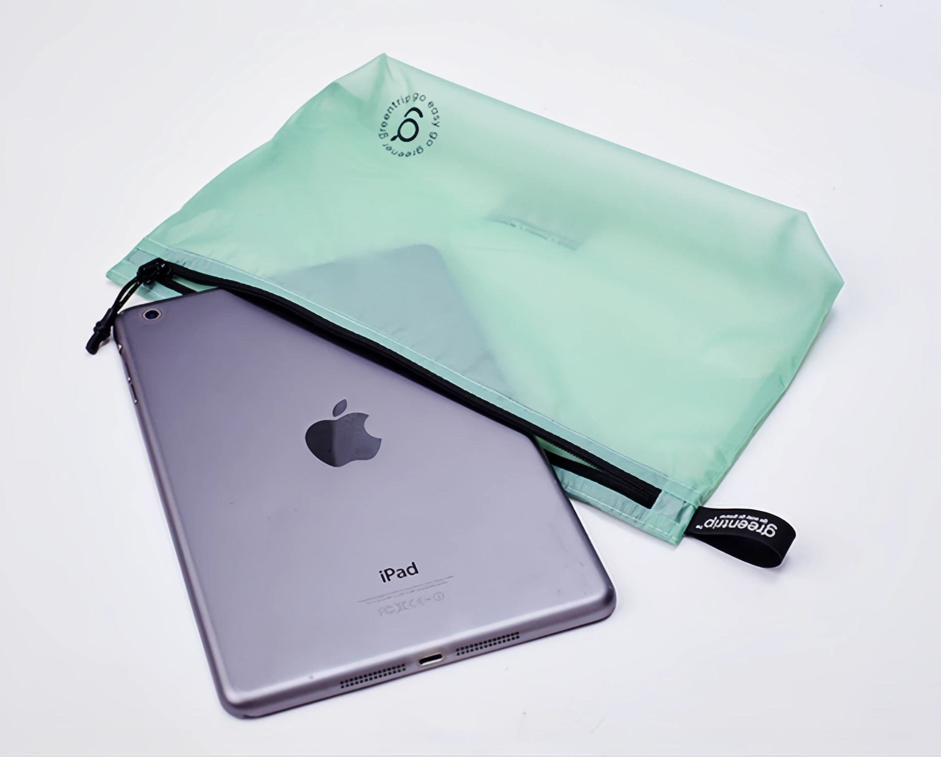 Silver iPad with a green travel storage bag on a white background