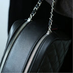 Black leather makeup bag with silver zippers and chain strap.