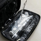 Black dual-zip toiletry bag with water splashed onto the inside