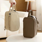 Two dual-zip cosmetic bags on a white surface with a blurred indoor background
