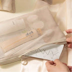 Mesh storage bag being held by hands on a light background