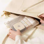 Hand holding a beige pouch with a mesh pocket inside, against a white background